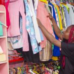 Beautiful woman checking Multi-coloured wardrobe showcase and smiling